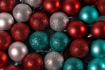 Multi-colored balls on a dark and blue background. Red, blue, purple, silver, gold Christmas toys