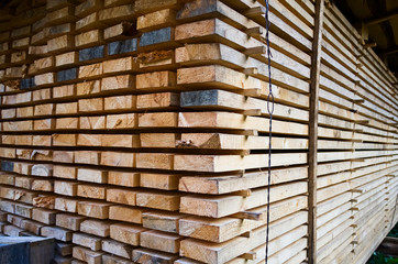 Stack of new wooden planks close up. Wooden boards for house building and construction material.