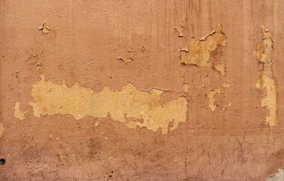 old wall with peeling paint - rough dirty texture for a background