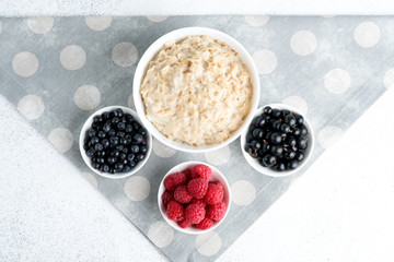 Oatmeal with berries and fruits on a light background. Healthy breakfast. Top view.