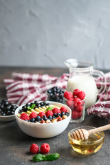 Oatmeal with berries and fruits on a  dark background. Healthy breakfast.