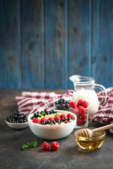Oatmeal with berries and fruits on a  dark background. Healthy breakfast.