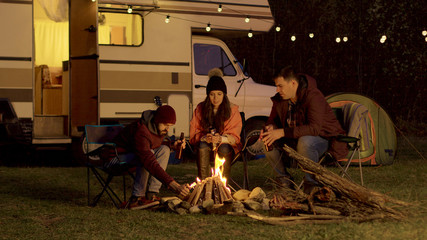 Friend of a couple helping to light the camp fire