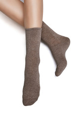 Cropped shot of a girl's foots, lying on a white background. It is grey socks on her foots. 