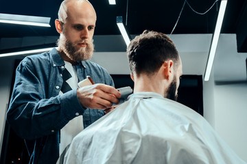 YOUNG HANDSOME BEARDED MAN IN BARBERSHOP