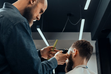 YOUNG HANDSOME BEARDED MAN IN BARBERSHOP