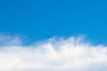 The sky is bright and the clouds are arranged in a long line below like waves. During the daytime.