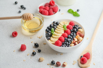 Healthy breakfast. Oatmeal with berries and fruits and milk on a light background copy space.