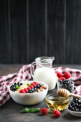 Healthy breakfast. Oatmeal with berries and fruits and milk on a dark background copy space.