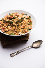 Oats Chivda / Chiwda is a healthy indian recipe with added chilli, peanuts, cashew, almond and curry leaf for flavour. Selective focus