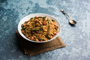 Oats Chivda / Chiwda is a healthy indian recipe with added chilli, peanuts, cashew, almond and curry leaf for flavour. Selective focus