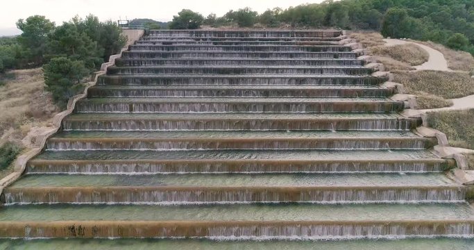 Escalera de cascadas de agua vista frontal desde dron hacia arriba