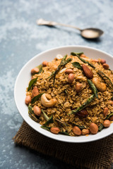 Oats Chivda / Chiwda is a healthy indian recipe with added chilli, peanuts, cashew, almond and curry leaf for flavour. Selective focus