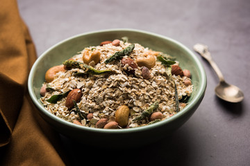 Oats Chivda / Chiwda is a healthy indian recipe with added chilli, peanuts, cashew, almond and curry leaf for flavour. Selective focus