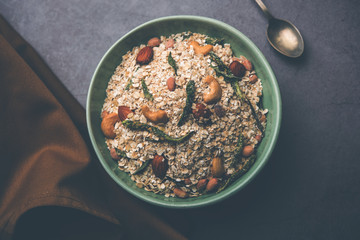 Oats Chivda / Chiwda is a healthy indian recipe with added chilli, peanuts, cashew, almond and curry leaf for flavour. Selective focus