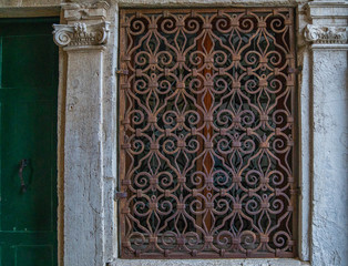 Old building in Venice, Italy. Detail of an old vintage window with rusty decorative bars. Travel inspiration.