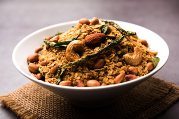 Oats Chivda / Chiwda is a healthy indian recipe with added chilli, peanuts, cashew, almond and curry leaf for flavour. Selective focus