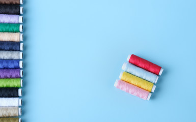 Thread tube colorful on blue background top view and copy space