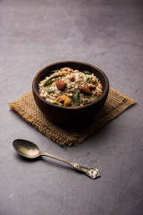 Oats Chivda / Chiwda is a healthy indian recipe with added chilli, peanuts, cashew, almond and curry leaf for flavour. Selective focus