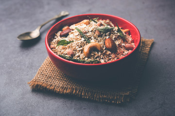 Oats Chivda / Chiwda is a healthy indian recipe with added chilli, peanuts, cashew, almond and curry leaf for flavour. Selective focus