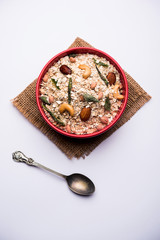 Oats Chivda / Chiwda is a healthy indian recipe with added chilli, peanuts, cashew, almond and curry leaf for flavour. Selective focus