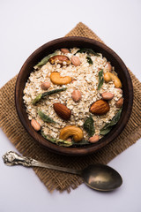 Oats Chivda / Chiwda is a healthy indian recipe with added chilli, peanuts, cashew, almond and curry leaf for flavour. Selective focus