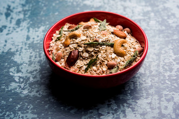 Oats Chivda / Chiwda is a healthy indian recipe with added chilli, peanuts, cashew, almond and curry leaf for flavour. Selective focus