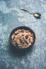 Oats Chivda / Chiwda is a healthy indian recipe with added chilli, peanuts, cashew, almond and curry leaf for flavour. Selective focus