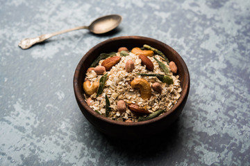 Oats Chivda / Chiwda is a healthy indian recipe with added chilli, peanuts, cashew, almond and curry leaf for flavour. Selective focus