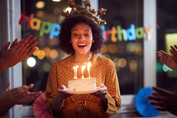 woman blowing out her birthday candles and celebrating Birthday