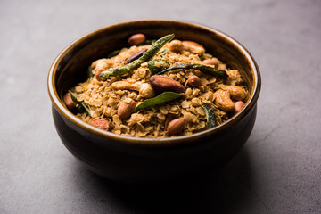 Oats Chivda / Chiwda is a healthy indian recipe with added chilli, peanuts, cashew, almond and curry leaf for flavour. Selective focus