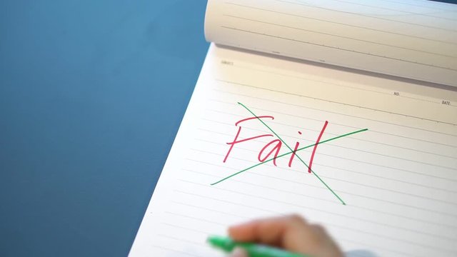 Fild text with a hand with a red pen And crossed out with a green pen on the notebook. Success message by hand with a green pen below the fail. The concept of ​​not giving up on failure.