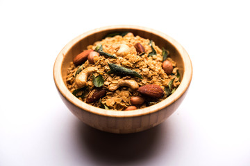 Oats Chivda / Chiwda is a healthy indian recipe with added chilli, peanuts, cashew, almond and curry leaf for flavour. Selective focus
