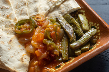 Mexican quesadillas with red sauce and grilled nopal cactus on dark background