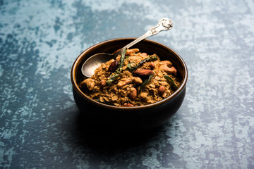 Oats Chivda / Chiwda is a healthy indian recipe with added chilli, peanuts, cashew, almond and curry leaf for flavour. Selective focus