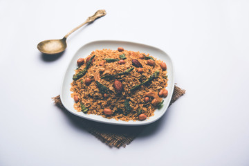 Oats Chivda / Chiwda is a healthy indian recipe with added chilli, peanuts, cashew, almond and curry leaf for flavour. Selective focus