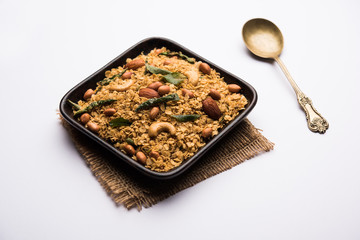 Oats Chivda / Chiwda is a healthy indian recipe with added chilli, peanuts, cashew, almond and curry leaf for flavour. Selective focus