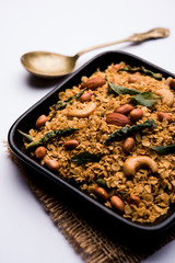 Oats Chivda / Chiwda is a healthy indian recipe with added chilli, peanuts, cashew, almond and curry leaf for flavour. Selective focus