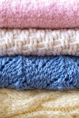 Hand knitted sweaters and blankets in pastel colors