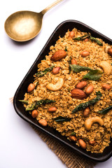 Oats Chivda / Chiwda is a healthy indian recipe with added chilli, peanuts, cashew, almond and curry leaf for flavour. Selective focus