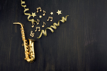Fototapeta na wymiar Happy New Year banner with gold saxophone as a party and celebration symbol. Top view
