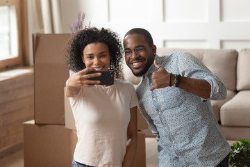 Obraz premium Happy african couple takes selfie photo carton boxes on background