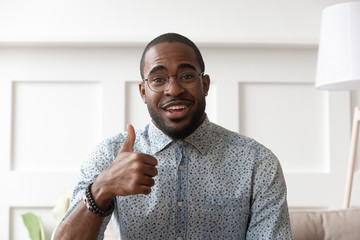 African man in glasses showing thumbs up looking at camera