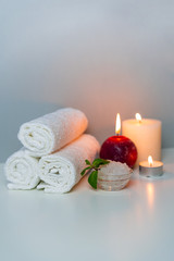 SPA & Natural health concept photo, vertical orientation. Candles, stack of white towels, sea salt. 