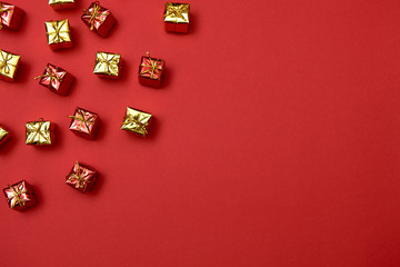 Creative Christmas pattern with yelloe and red gifts on red background, copy space. Minimal, winter, new year concept. Top view, flat lay