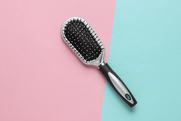 Stylish hairbrush on pink blue pastel background. Women's Hair Care Accessories. Top view
