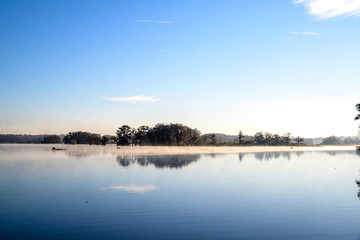Misty Morning Lake with Autumn Colored Trees and Foliage