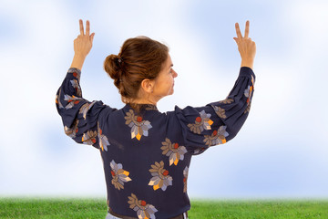 Woman raises both hands in the air