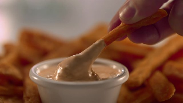 French fry dipped in mayo in slow motion