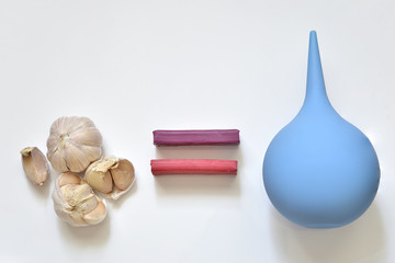 Garlic and enema on a light background.